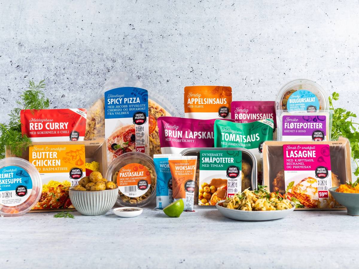 Et utvalg ferdigretter og ingredienser for ukens middager, inkludert pizza, curry, pasta og salater, på et bord.