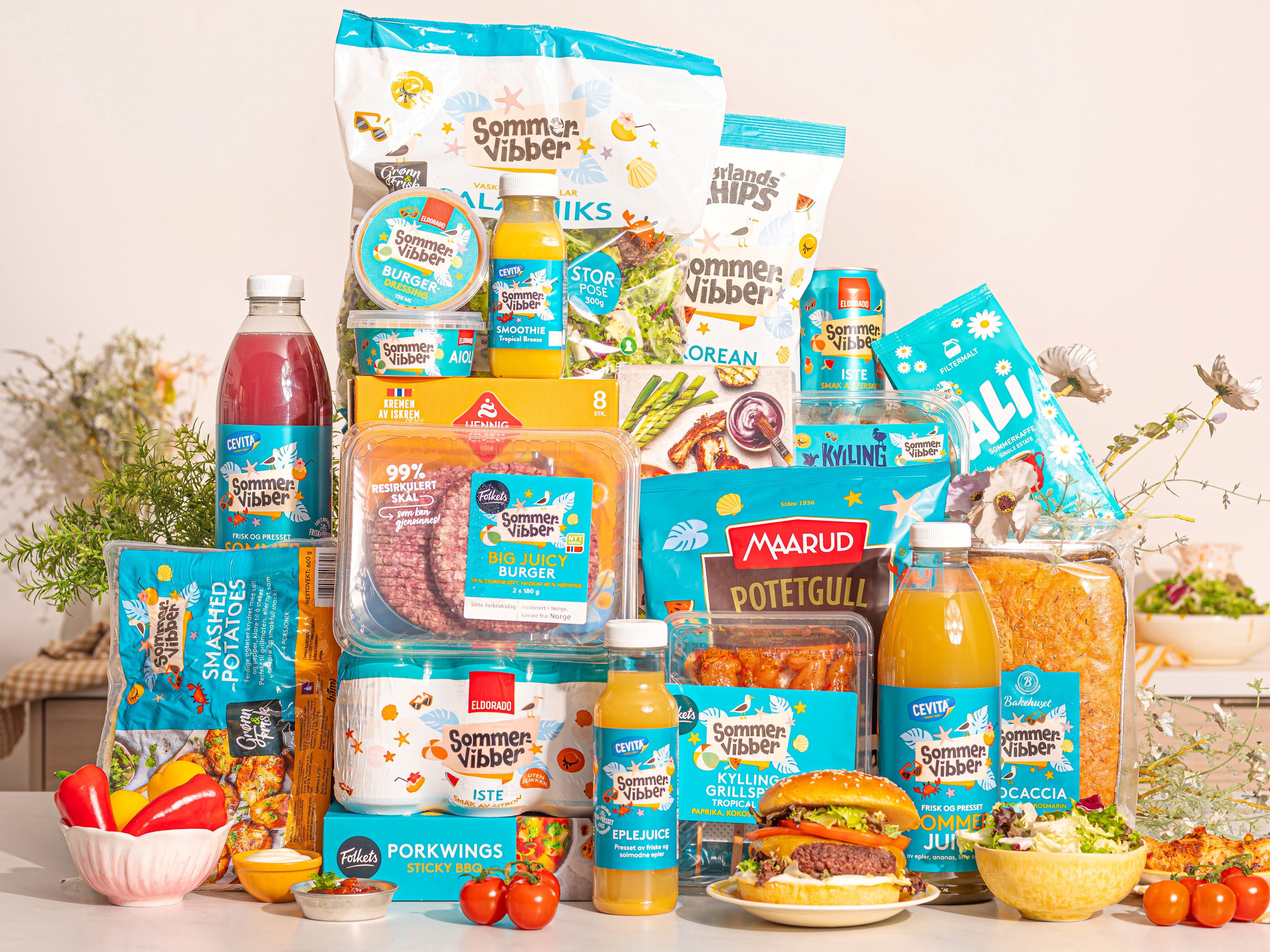 Et utvalg av sommerrelaterte mat- og drikkevarer, inkludert juice, snacks og ferdigmat, på en hvit bakgrunn.