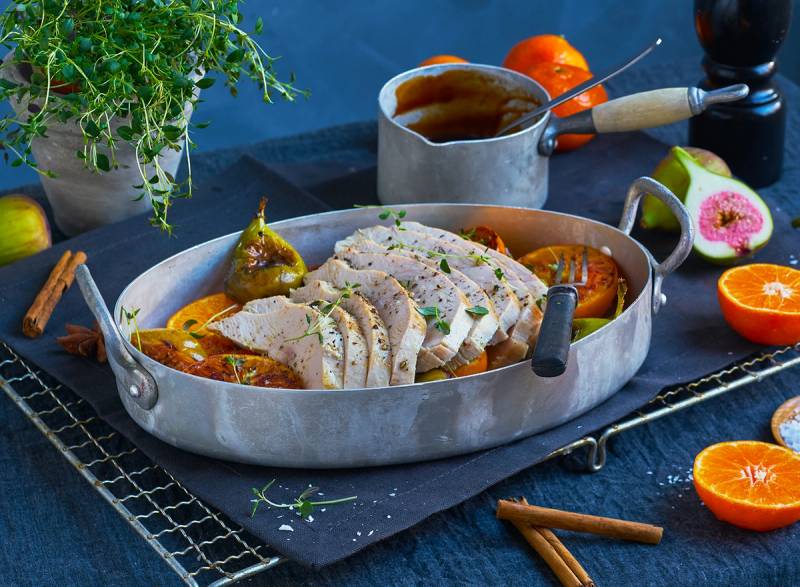 Saftig kalkunfilet skåret i skiver og servert med grønnsaker og saus på en oval tallerken.