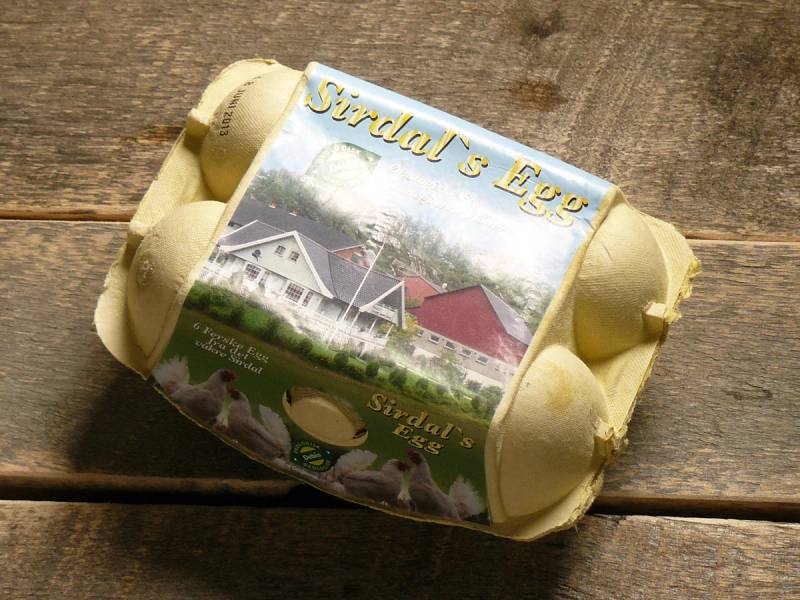 Eggkartong med Sirdals Egg-merke plassert på en treflate.