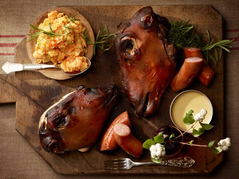 Smalahove servert med poteter, urter og saus på et serveringsfat.