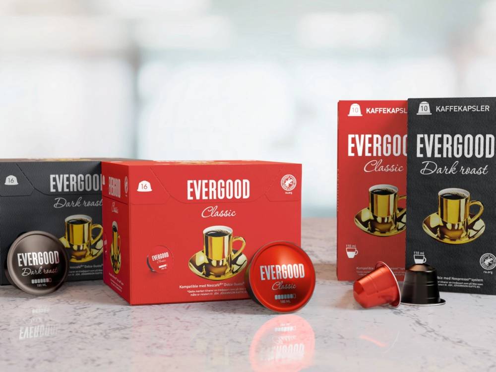 Ulike Evergood kaffekapsler og esker på et kjøkkenbord, med en bakgrunn av et kjøkkenvindu.