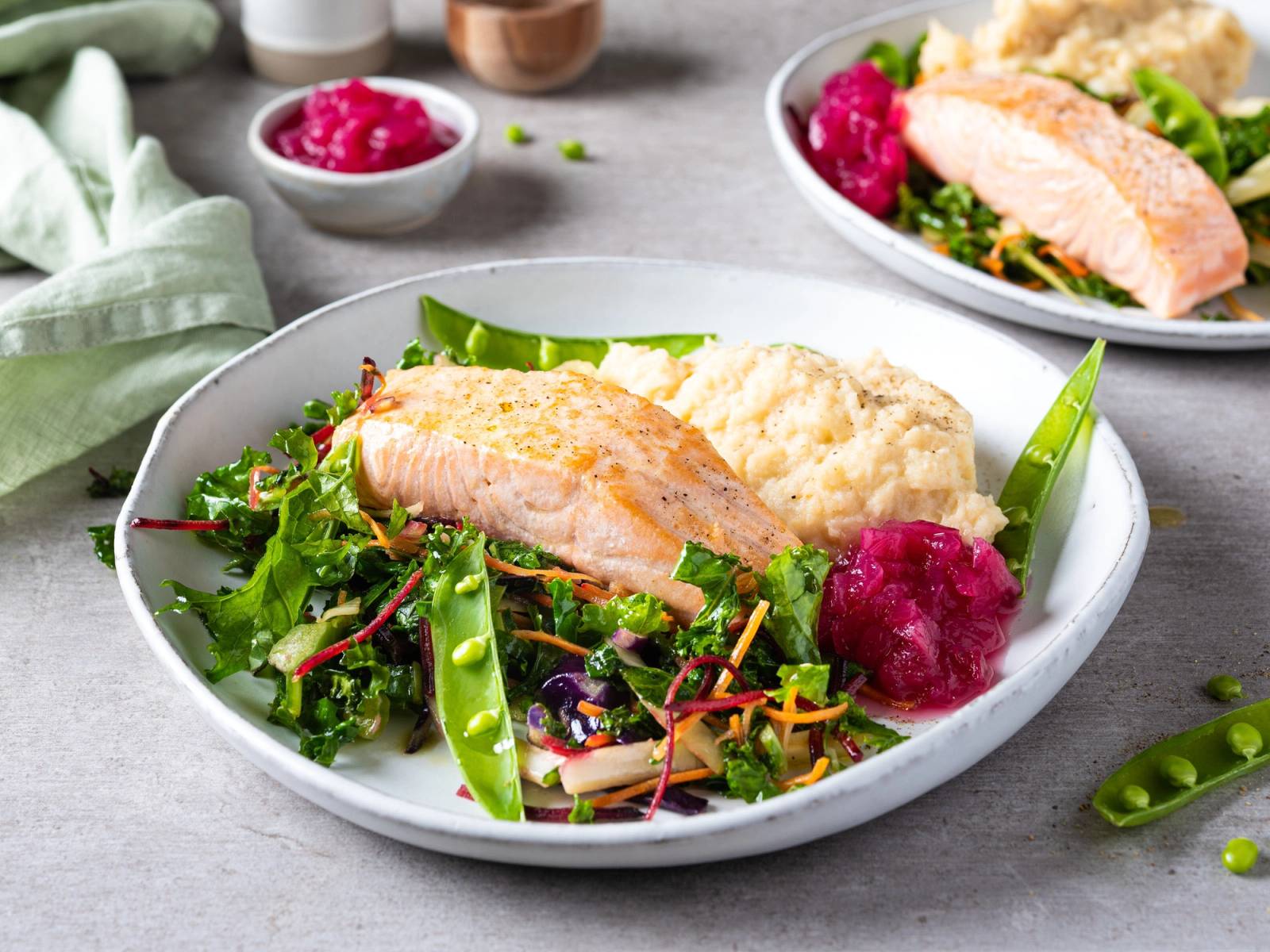 Laksefilet servert med sellerorotmos og grønnsaker på en hvit tallerken.