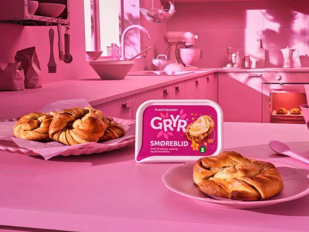 En kjøkkenbenk med en skål croissanter og en pakke med Gryr smørebar, med rosa farget kjøkken i bakgrunnen.