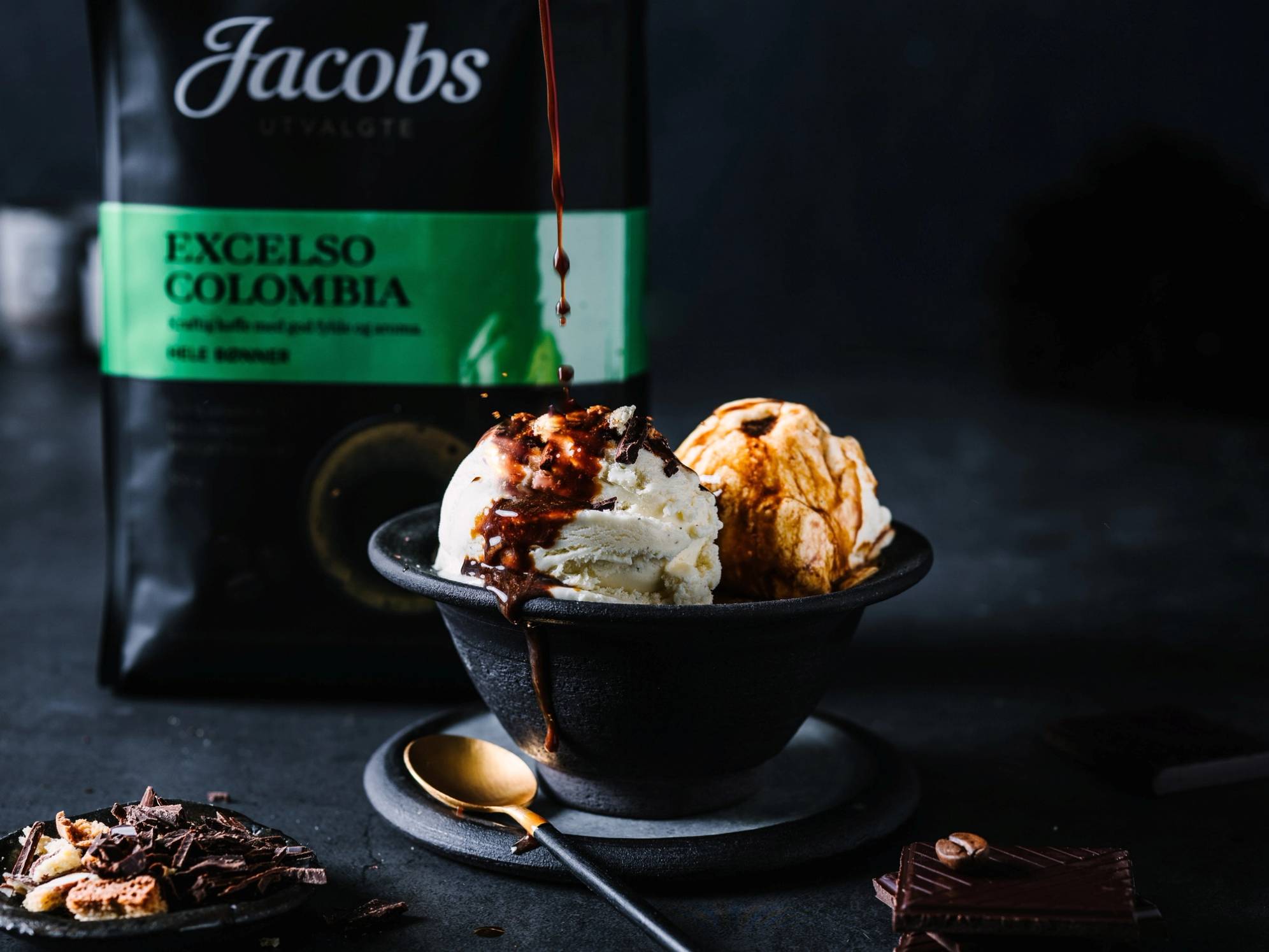 En kopp med affogato, som inneholder iskrem og espresso, med en flaske med alkohol i bakgrunnen.