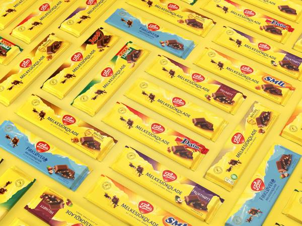 Ulike sjokoladestenger og godteripakker lagt ut på en overflate, med flere smaksvarianter og farger.