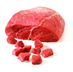 Stykke av storfekjøtt med små terninger av kjøtt rundt på en hvit bakgrunn.