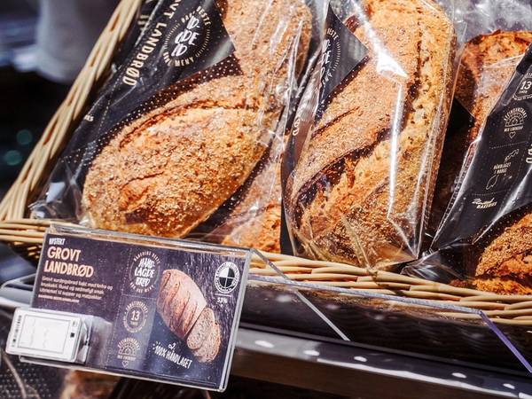 Brødskalaen viser ulike typer brød i en butikkhylle, pakket inn i plast.