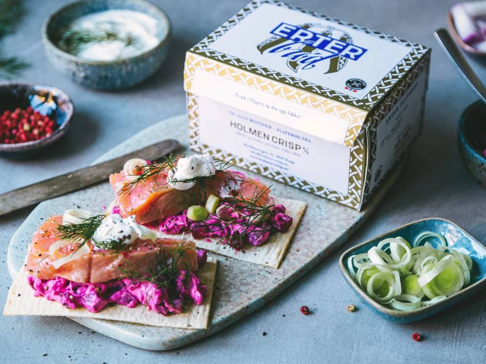 Holmen Crisp-kasse med lakse- og rødbetebrikker omgitt av små skåler med grønnsaker og bær