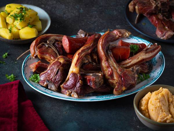 Pinnekjøtt med kålrotstappe og poteter på et serveringsfat, klar til julen feiring