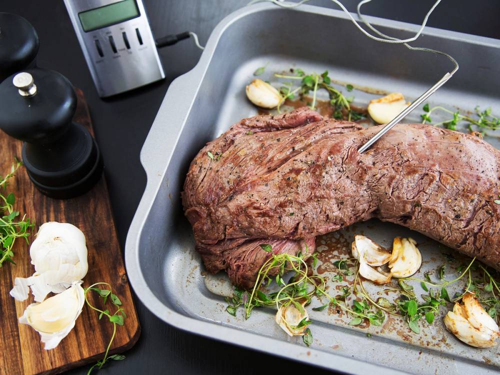 Slik steker du biff i en ildfast form med hvitløk og urter, klar til å stekes i ovnen.
