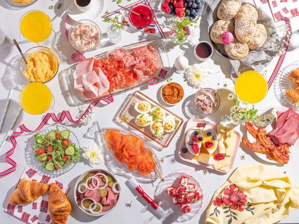 Frokostbord med ulike småretter, kaker og drikke til 17. mai-feiring.