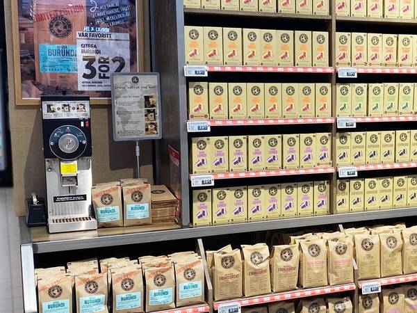 Kaffe på hyller med kaffekvern i bakgrunnen i en butikk