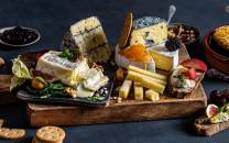 Ulike oster og tilbehør på et serveringsbrett, klar for helgekos.