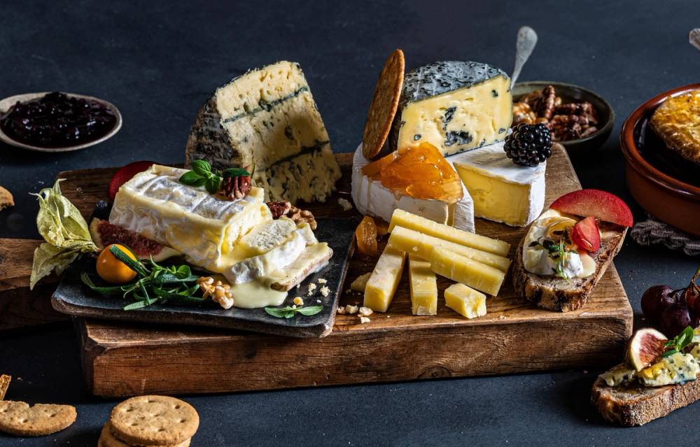 Ulike oster og tilbehør på et serveringsbrett, klar for helgekos.
