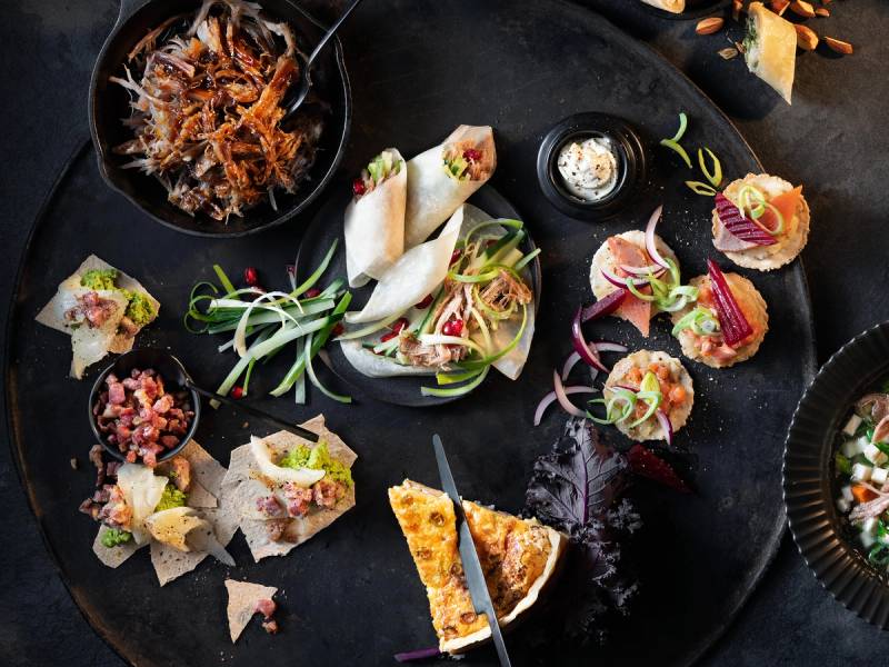 Ulike julematrester oppbevart i små tallerkener og skåler på et svart bord.