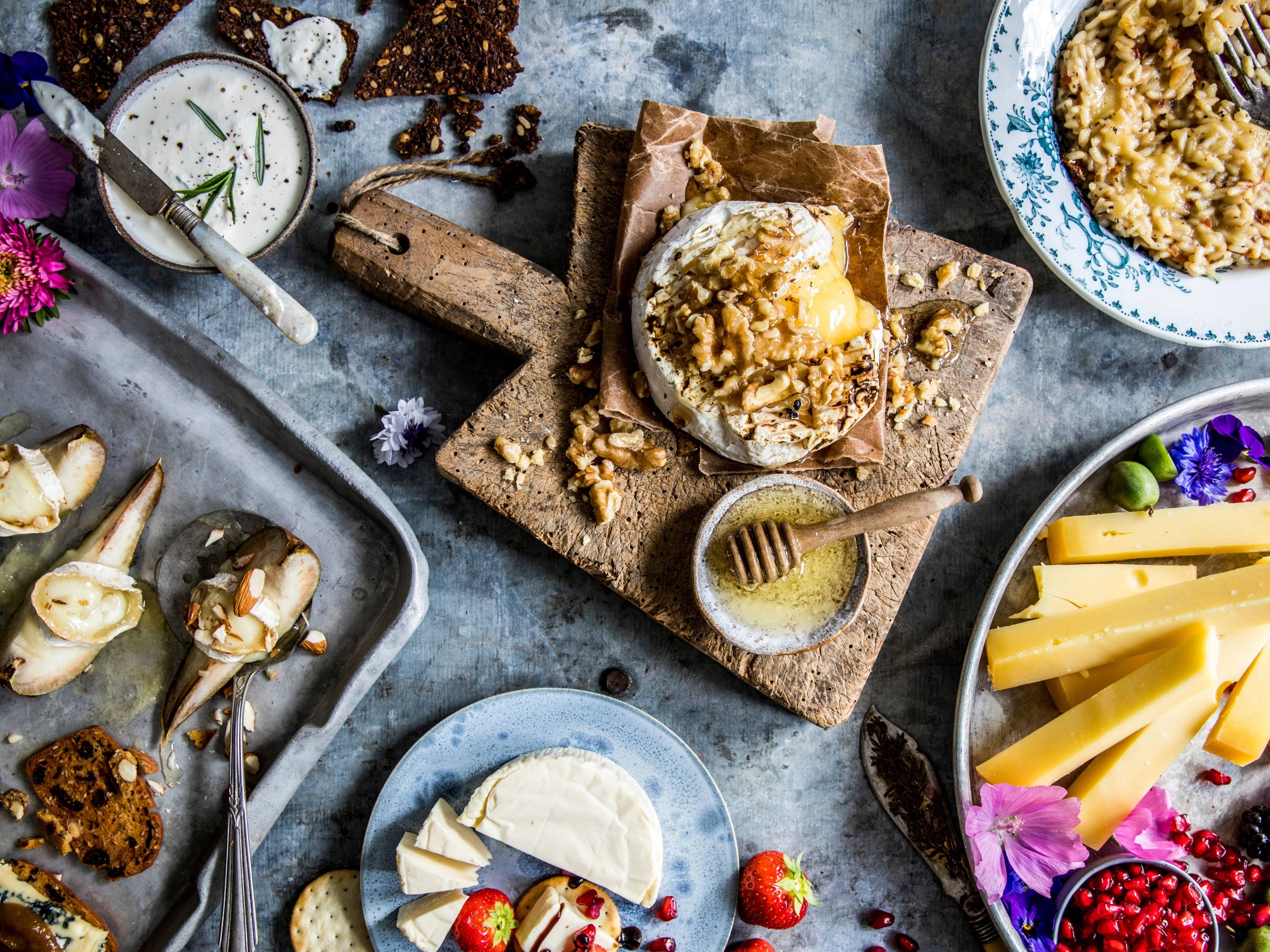 Et bord med ost, kjeks, syltetøy og frukt, klar for å nytes som en del av et måltid eller snacks.