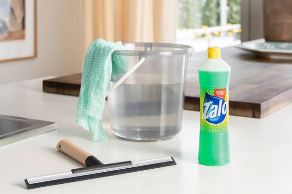 En bøtte med rengjøringsmiddel og en klut på en kjøkkenbenk, klar til rengjøring.