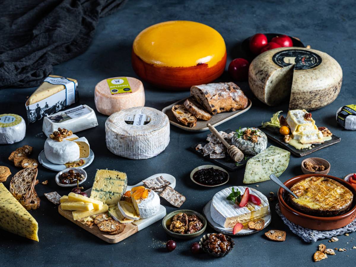 Et utvalg av ulike oster, kjeks og småretter på et bord, klare til å nytes i helgen.