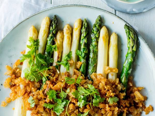 Grønne og hvite asparges med sprøtt dryss og noen urter på en tallerken