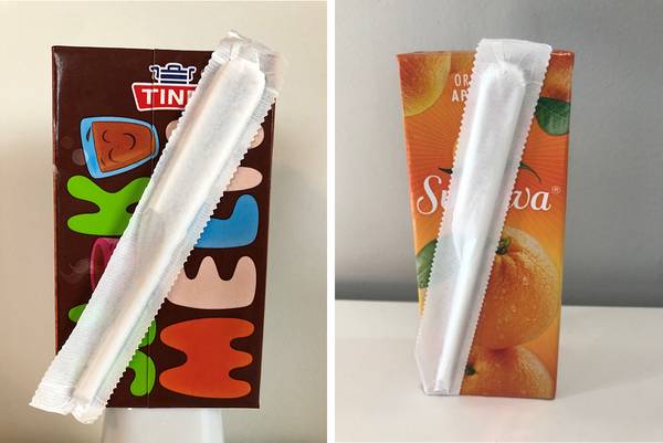 To juicekartonger med sugerør plassert oppå, en med sjokoladesmak og en med appelsinsmak.