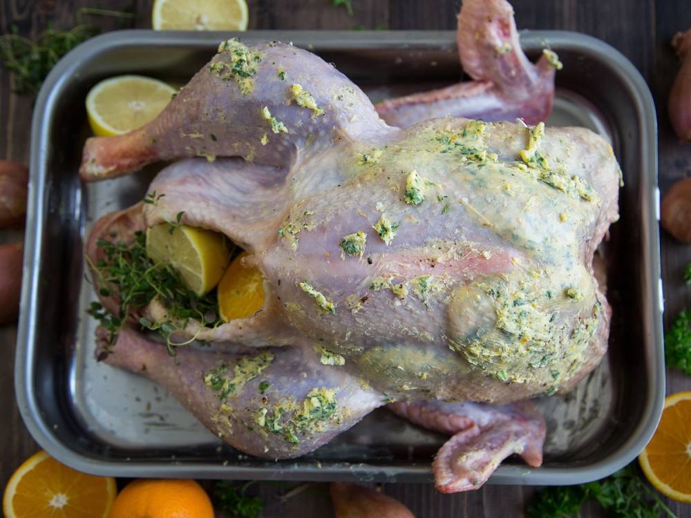 En rå kalkun med sitronbiter, urter og krydder, klar til å bli stekt.