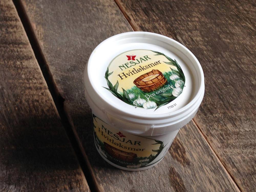 Nesjar-hovedbilde-krukke med hvit lokk og etikett som viser Nesjar-hudpleieprodukt, plassert på en treflate.