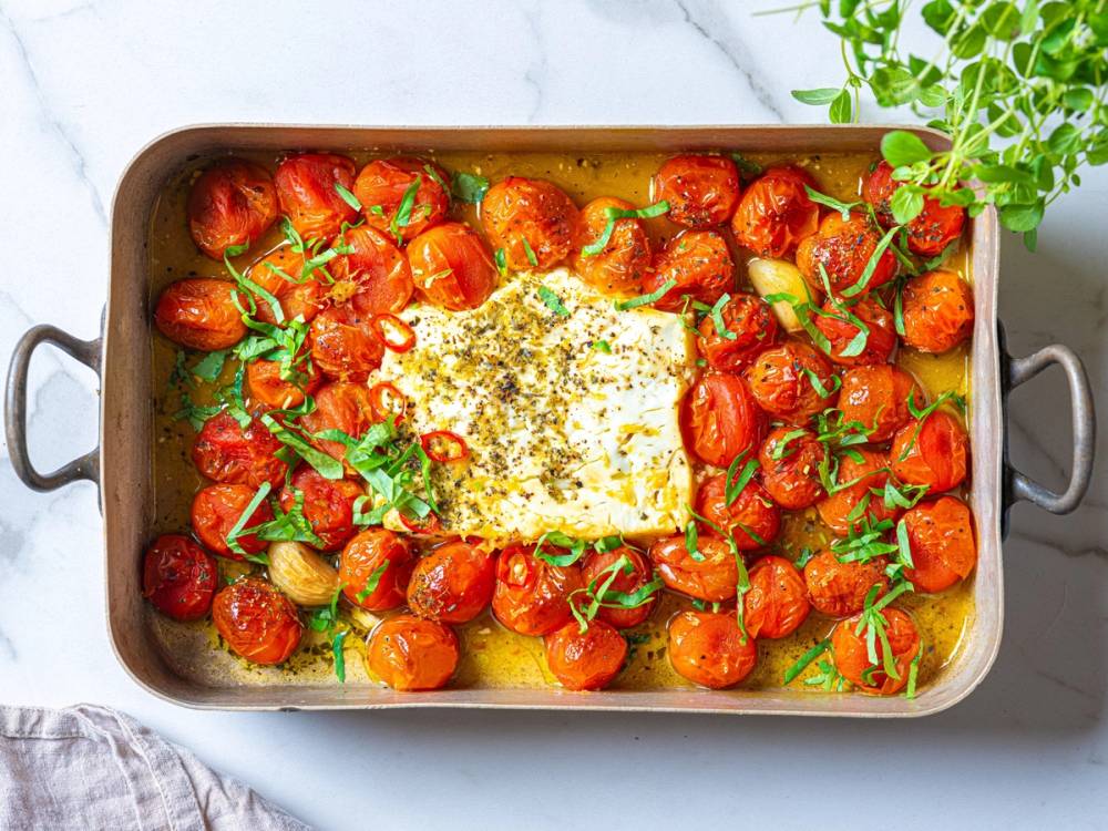 Pasta med cherrytomater, fetaost og frisk basilikum i en ildfast form.