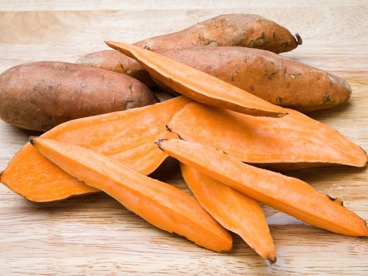 Skarne og hel søtpoteter ligger på et lyst trebord.