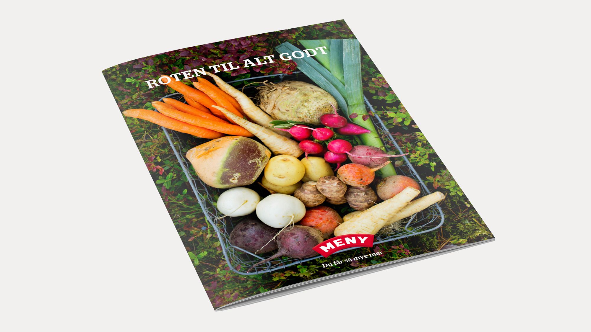 En bok med tittelen 'Roten til alt godt' ligger på en grønn, skogaktig bakgrunn, omgitt av ulike rotgrønnsaker og knoller.