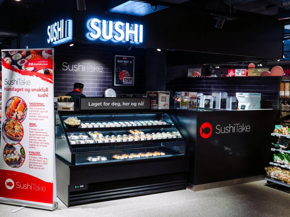 Sushibutikk med skilt som sier 'SUSHI' og en meny med bilder av sushi, i en butikk på Frogner.