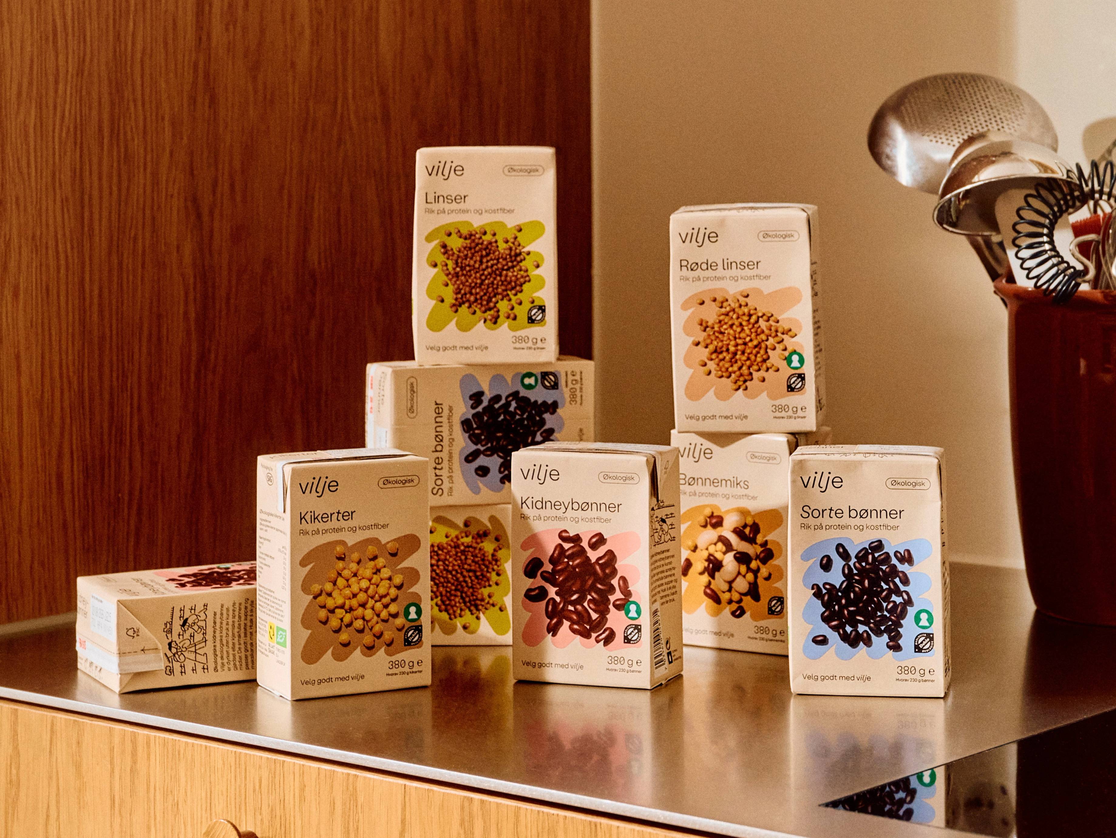 Ulike pakker med Vilje kosttilskudd med ulike farger og typer bær på en bordplate.