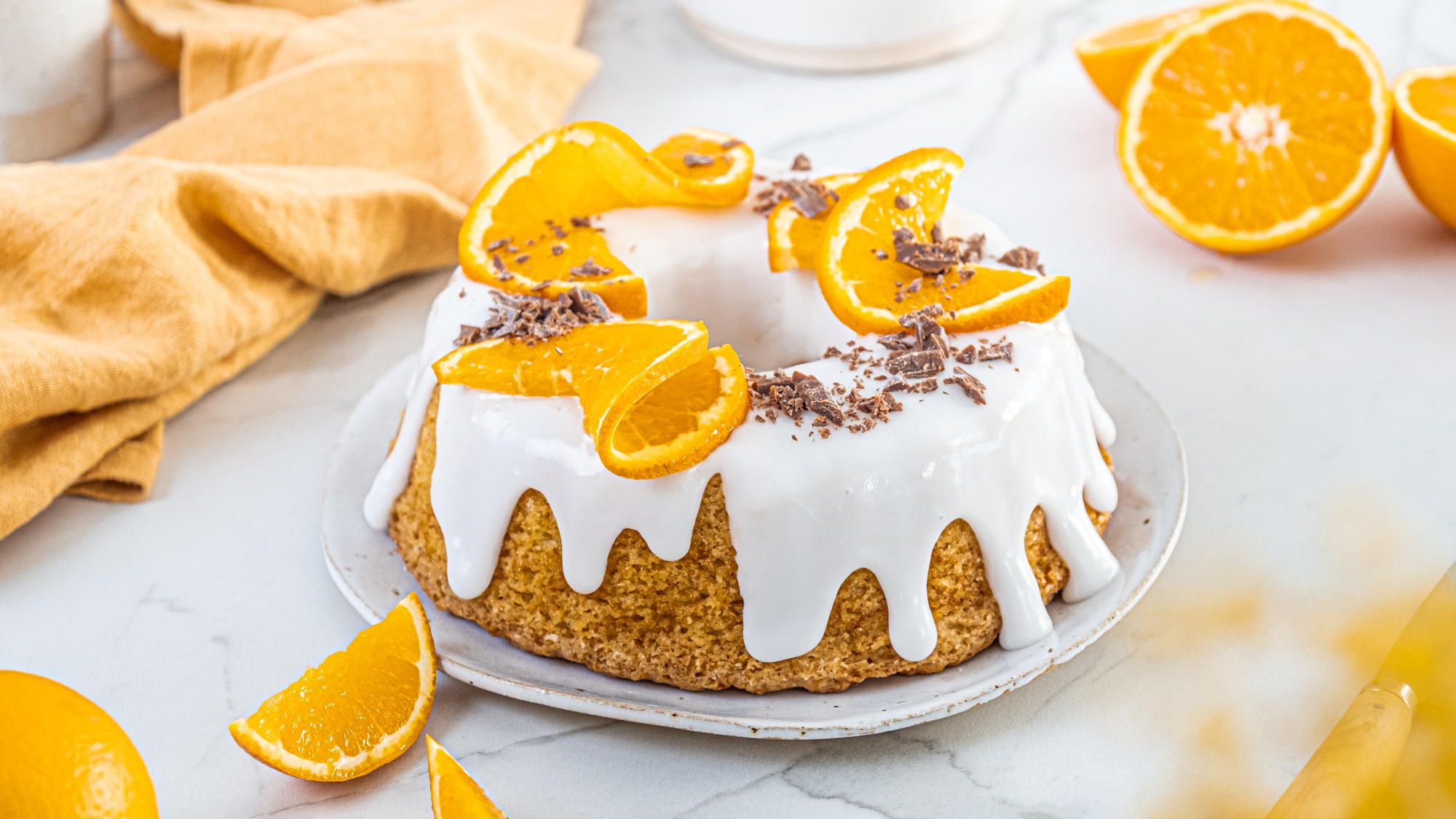 En saftig appelsinkake med melisglasur og appelsinskiver.