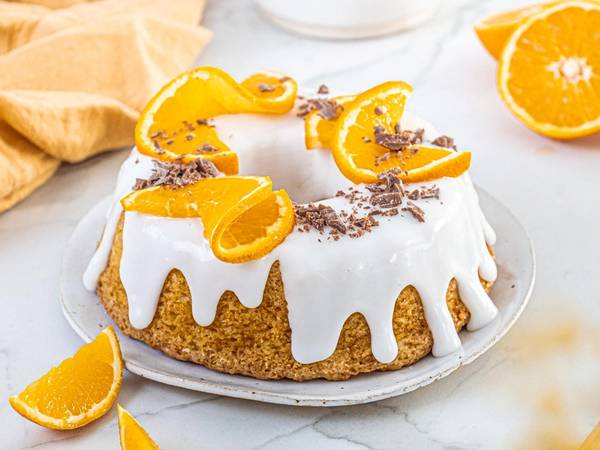 En saftig appelsinkake med melisglasur og appelsinskiver.