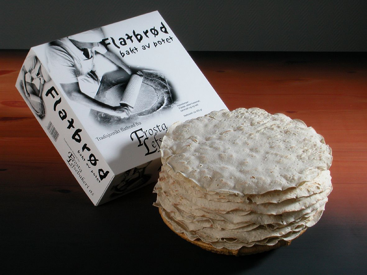 En pakke med flatbrød og en bunke flatbrød på en svart overflate.