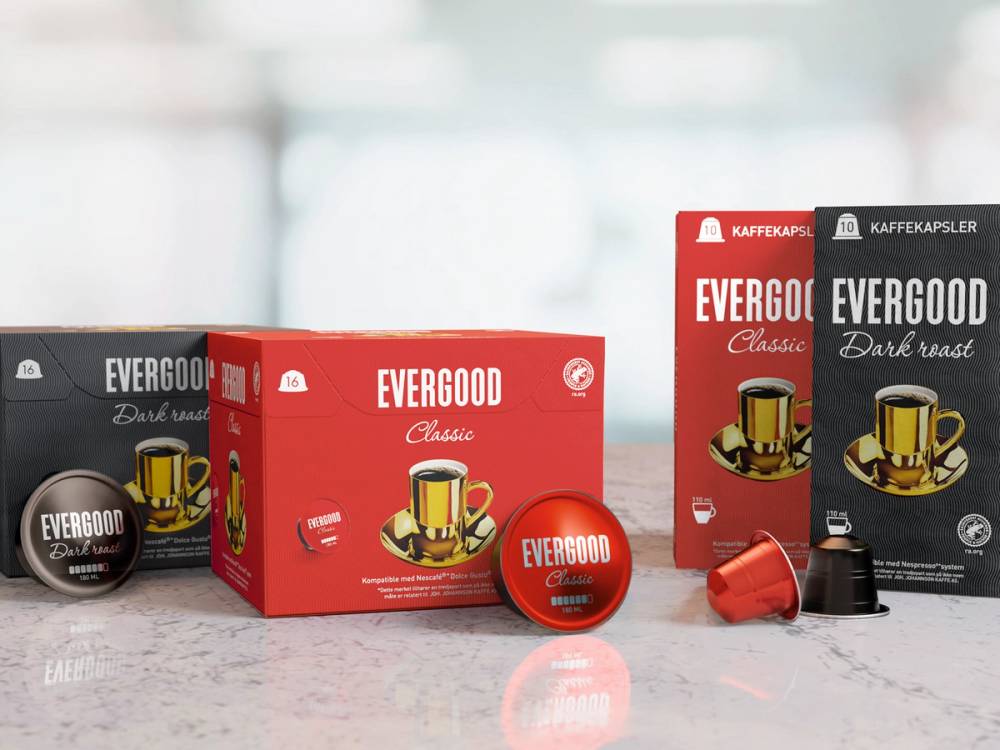 Ulike typer av Evergood kaffekapsler og esker på et bord, med en bakgrunn av et kjøkken eller butikkmiljø.