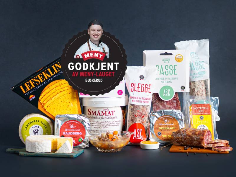 Et utvalg av matvarer og snacks på et bord, inkludert ost, kjeks, sjokolade og emballasjer med tekst, sannsynligvis fra Buskerud.