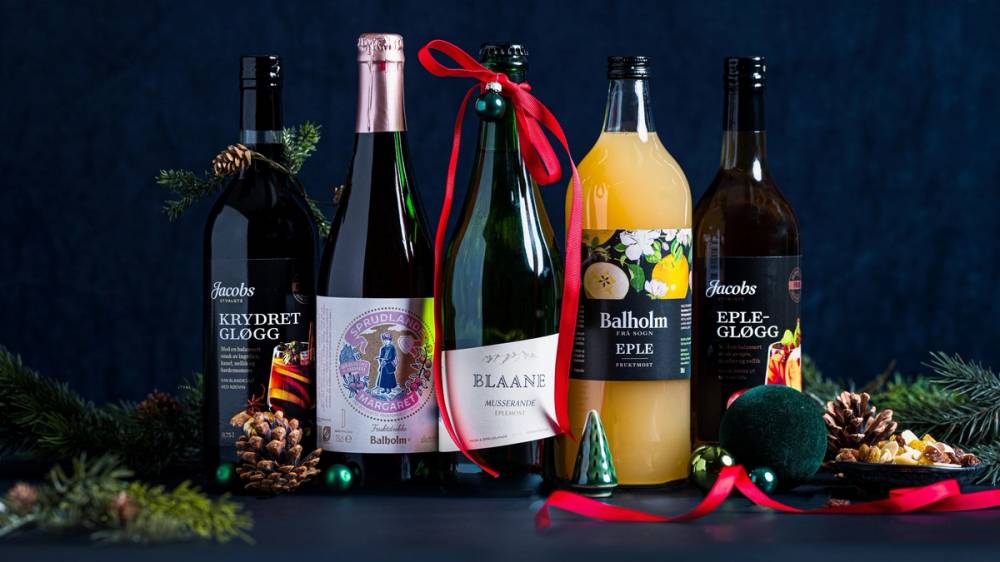 Flere flasker med alkoholholdige drikker og julepynt på et bord, klar til julen feiring.