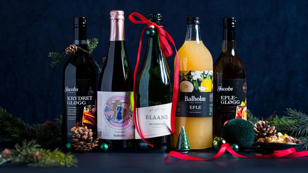 Flere flasker med alkoholholdige drikker og julepynt på et bord, klar til julen feiring.