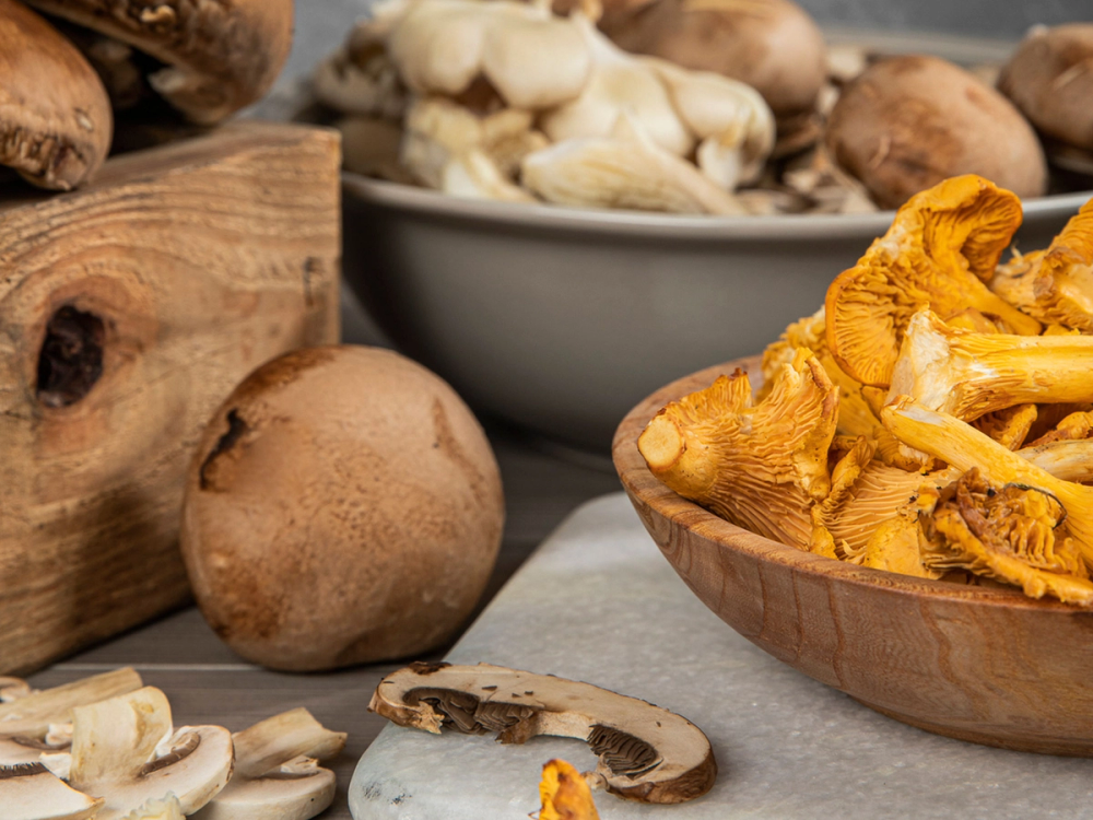Ulike sopp i ulike former og farger, inkludert gule og brune sopper, på et bord.