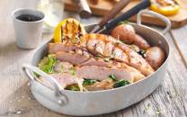 Flintstek med poteter og grønnsaker på et fat, omgitt av kjøkkenutstyr og en kopp med drikke.