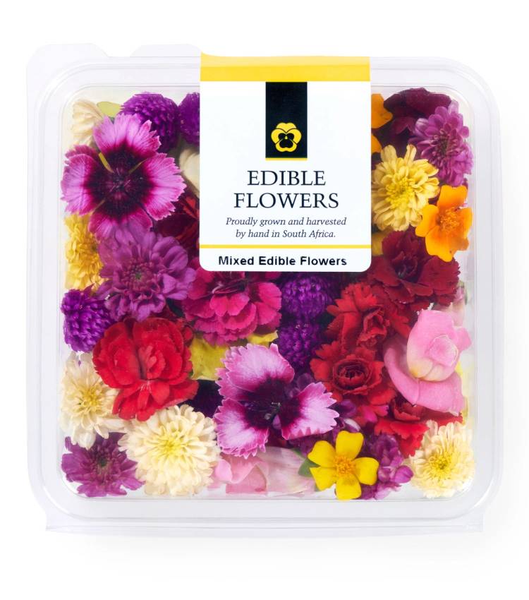 En plastboks med blandede spiselige blomster i ulike farger.