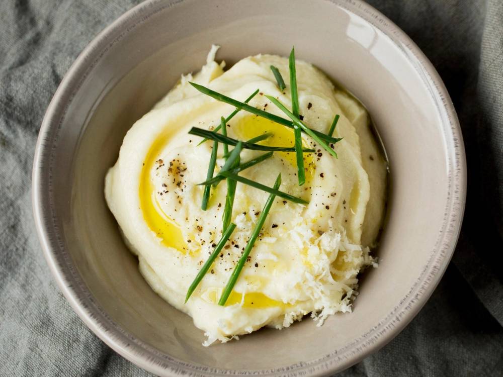 En skål med kokt egg toppet med hakket gressløk og litt pepper.