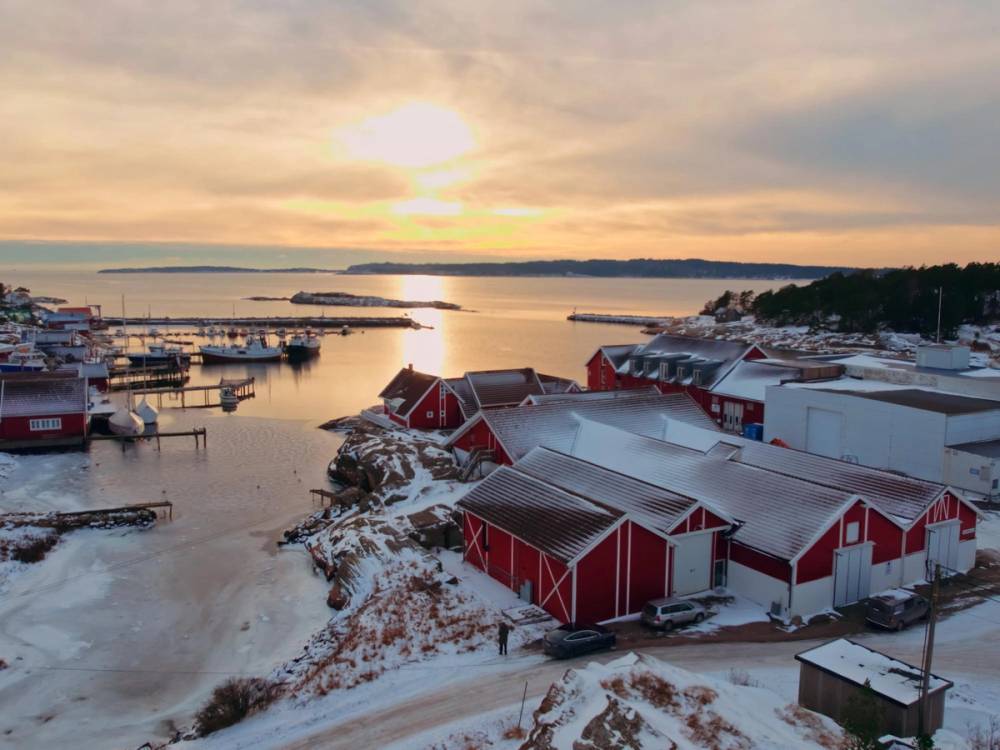 Røde bygninger ved vannkanten i solnedgang
