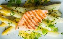 Hvit asparges med en skive laks og frisk dill på en tallerken