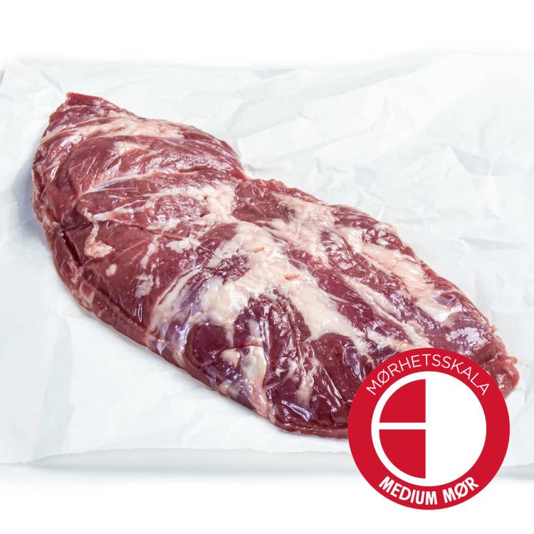 Et stykke rå Angus-spider steak med et lag av fett, plassert på hvitt papir, merket med en rød og hvit logo som indikerer medium mørkhet.