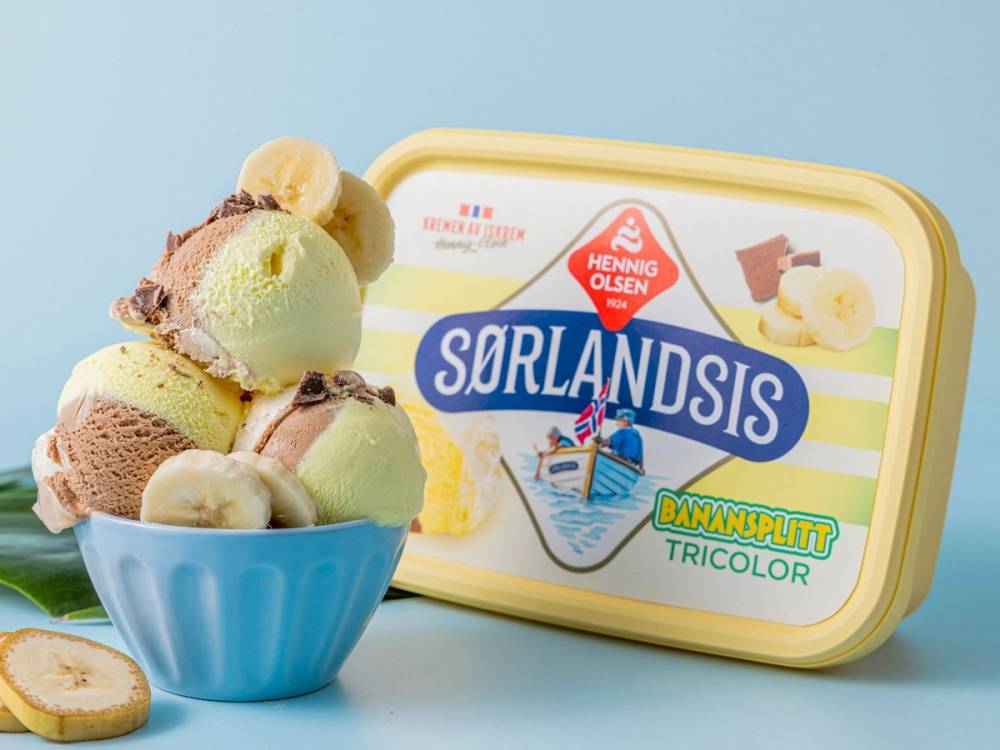 En bøtte med banansplit iskrem ved siden av en Hennig Olsen sorbetboks med banansplit-etikett, mot en lys blå bakgrunn.