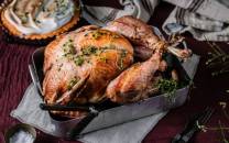 Stekt kalkun med urter på et serveringsfat, klar til Thanksgiving-middag.