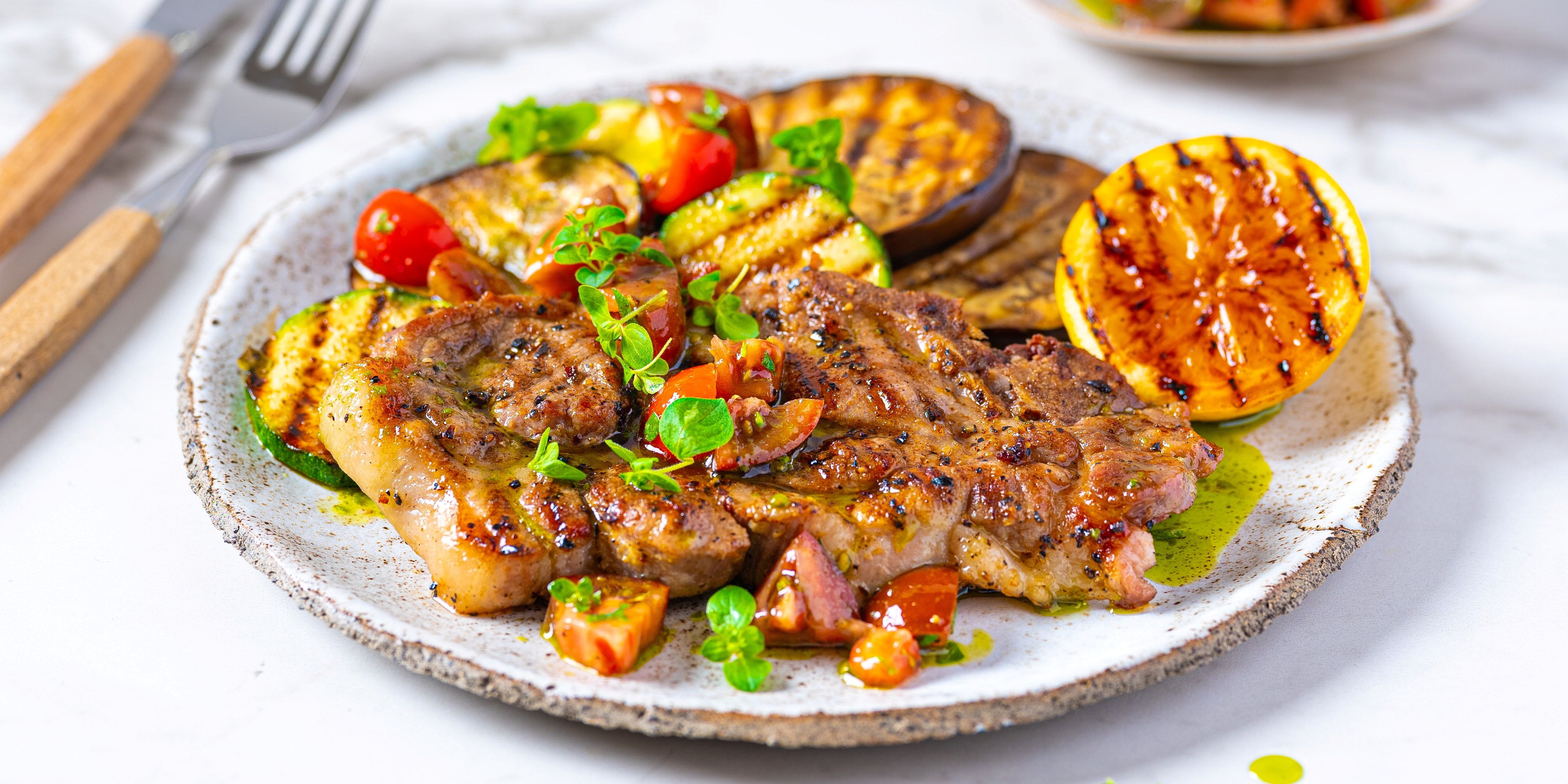 Marinert nakkekotelett med trøffelsmak servert med grillede grønnsaker på en tallerken.