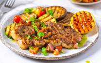 Marinert nakkekotelett med trøffelsmak servert med grillede grønnsaker på en tallerken.